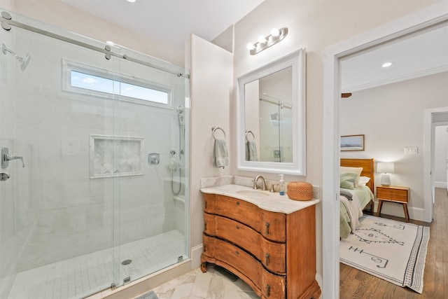 ensuite bathroom with a stall shower, connected bathroom, vanity, baseboards, and recessed lighting