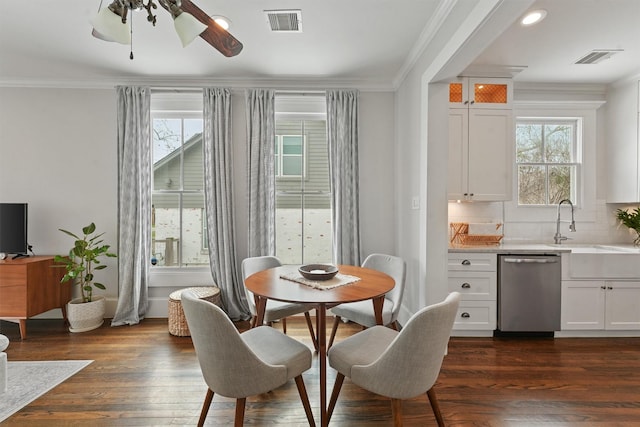 dining room featuring crown molding, visible vents, a ceiling fan, and dark wood-style flooring