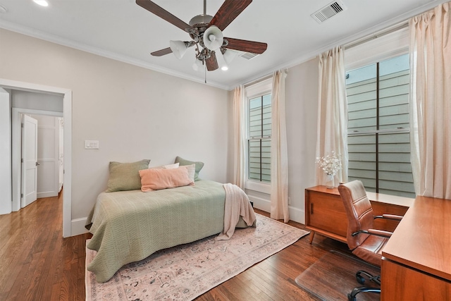 bedroom with hardwood / wood-style flooring, crown molding, multiple windows, and visible vents
