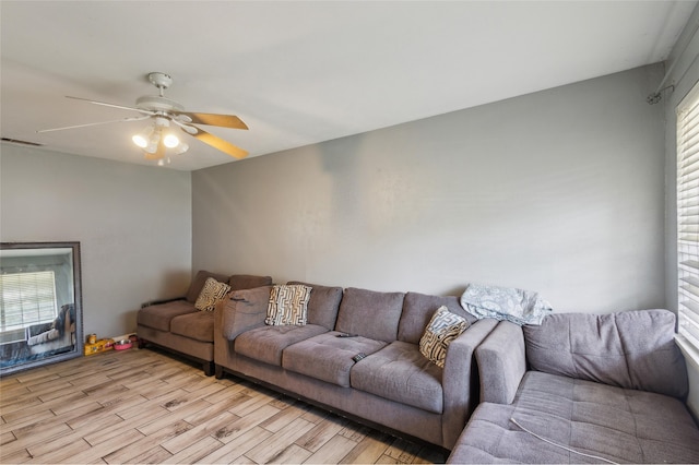 living room featuring light wood-style floors, visible vents, and a wealth of natural light
