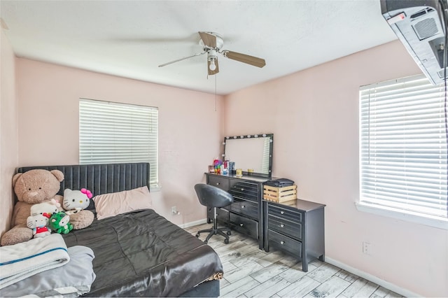 bedroom with baseboards, ceiling fan, and multiple windows