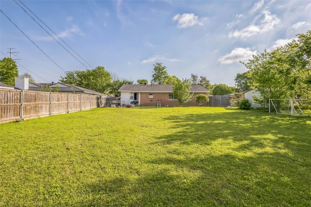 view of yard featuring a fenced backyard and an outdoor structure