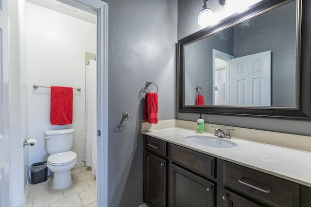 full bathroom featuring toilet, tile patterned floors, a textured wall, and vanity