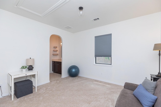 interior space with arched walkways, baseboards, visible vents, and light carpet