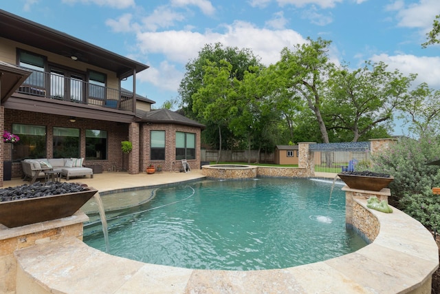 view of pool with an outdoor structure, a fenced backyard, a shed, an outdoor living space, and a patio area