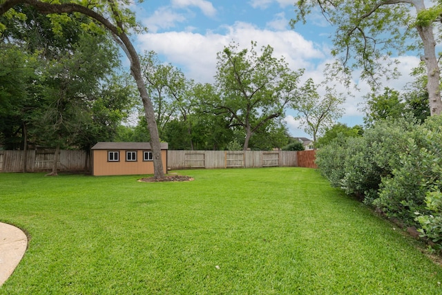 view of yard featuring a fenced backyard, an outbuilding, and a shed