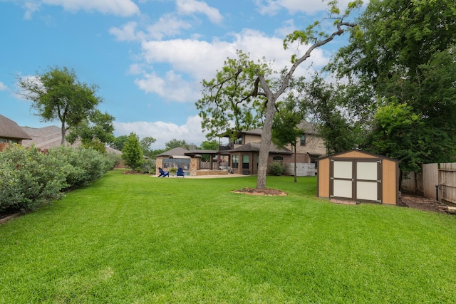 view of yard with a gazebo, an outbuilding, a fenced backyard, and a shed