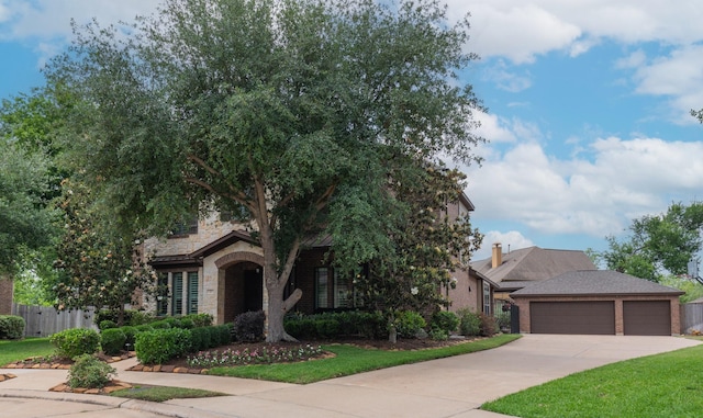 obstructed view of property featuring fence, driveway, brick siding, and a front yard