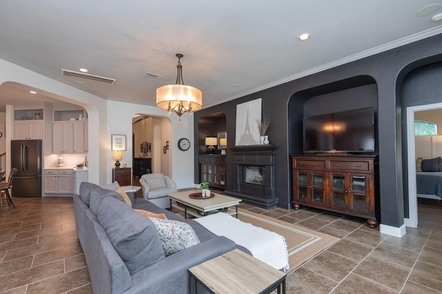 tiled living area with crown molding, arched walkways, recessed lighting, and visible vents