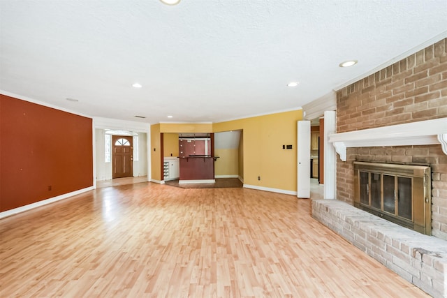 9402 Stockport Dr, Spring, TX 77379 - unfurnished living room with light wood finished floors, ornamental molding, baseboards, a brick fireplace, and recessed lighting