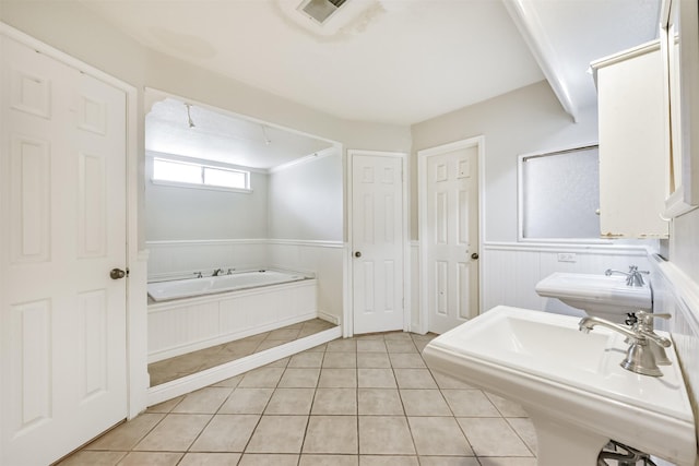 9402 Stockport Dr, Spring, TX 77379 - full bathroom with a bath, tile patterned flooring, a wainscoted wall, and a sink