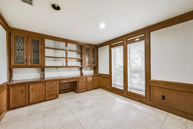 9402 Stockport Dr, Spring, TX 77379 - unfurnished office with built in desk, wainscoting, a textured ceiling, a decorative wall, and wood walls