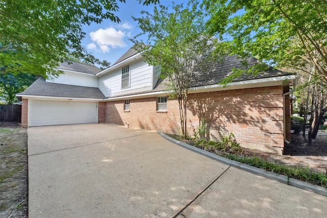 9402 Stockport Dr, Spring, TX 77379 - view of property exterior featuring brick siding, a garage, driveway, and roof with shingles