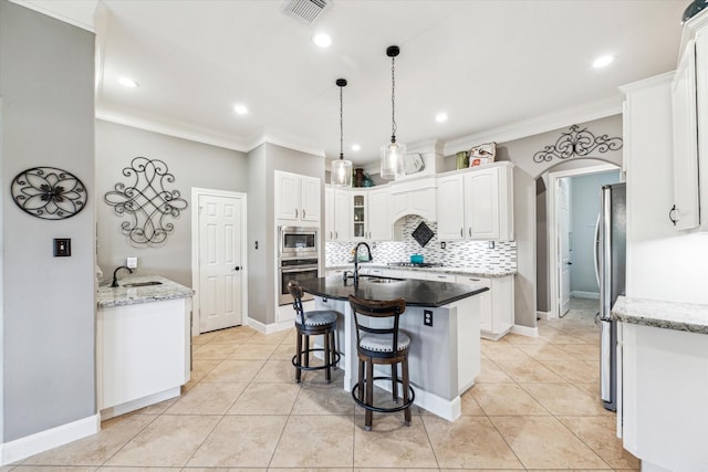 kitchen featuring visible vents, ornamental molding, appliances with stainless steel finishes, and backsplash