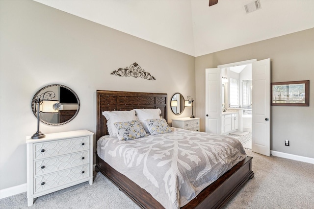 bedroom featuring light colored carpet, visible vents, baseboards, high vaulted ceiling, and connected bathroom