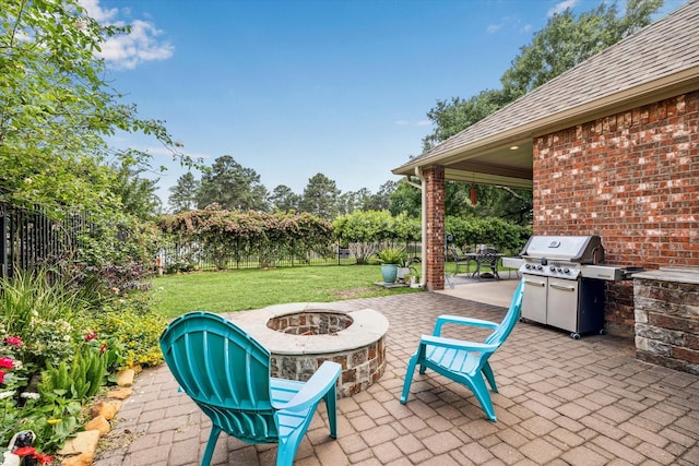 view of patio / terrace with grilling area, a fenced backyard, and an outdoor fire pit
