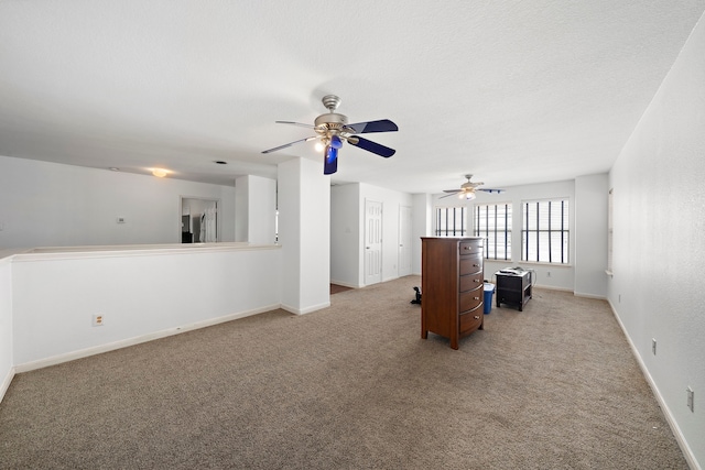 unfurnished living room featuring light colored carpet, ceiling fan, and baseboards