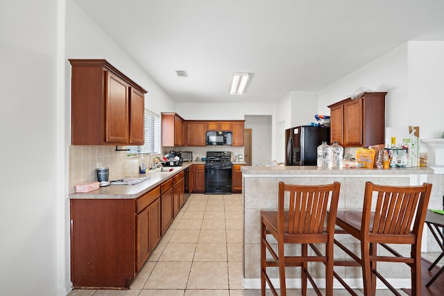 kitchen with light countertops, visible vents, decorative backsplash, black appliances, and a peninsula