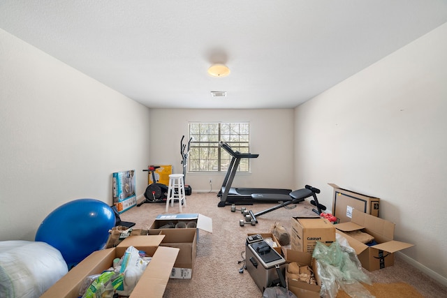 workout area with visible vents, baseboards, and carpet flooring