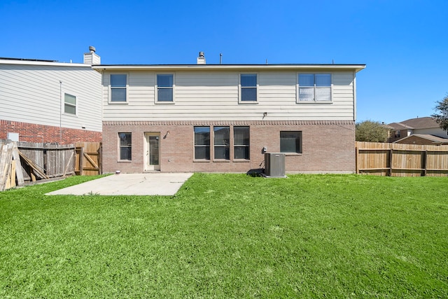 back of property with a fenced backyard, central AC unit, brick siding, a patio area, and a lawn