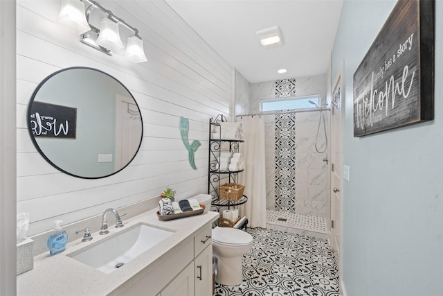 bathroom with a stall shower, wooden walls, vanity, and toilet