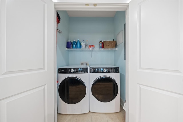 laundry area featuring independent washer and dryer, light tile patterned floors, and laundry area