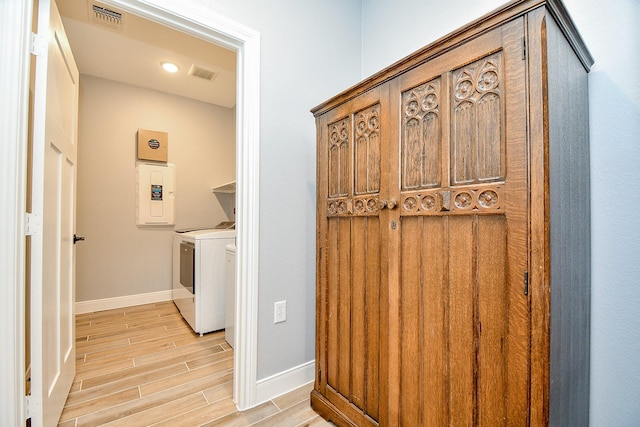 laundry room featuring independent washer and dryer, laundry area, light wood-type flooring, visible vents, and electric panel