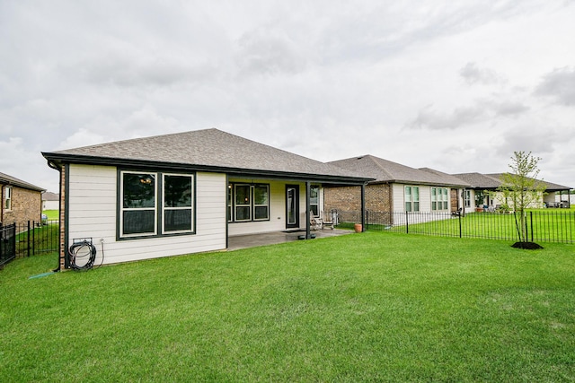 back of property featuring a yard, roof with shingles, a fenced backyard, and a patio area