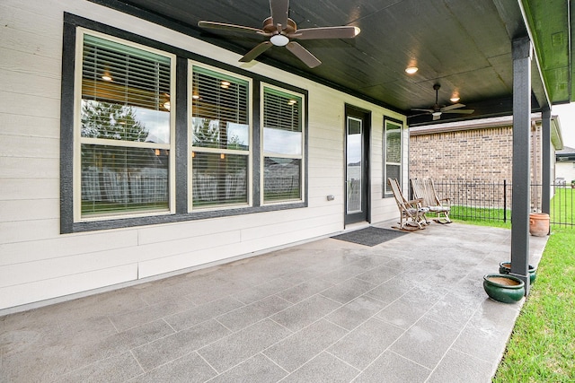 view of patio with a porch, fence, and a ceiling fan
