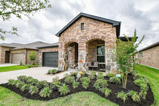 french country inspired facade with brick siding, a garage, and driveway