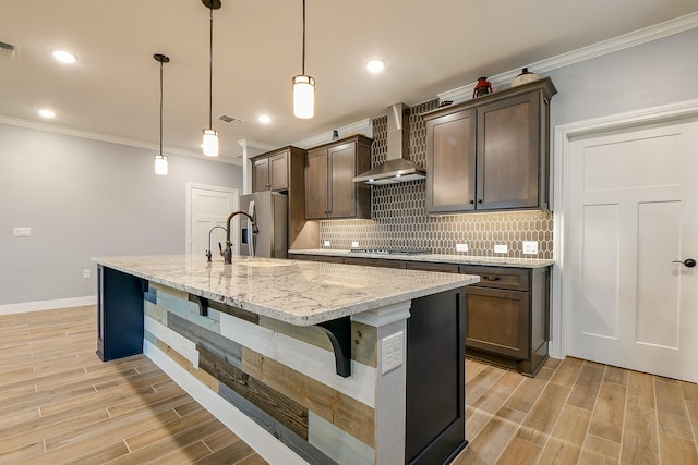 kitchen with crown molding, wall chimney exhaust hood, decorative backsplash, a kitchen bar, and visible vents