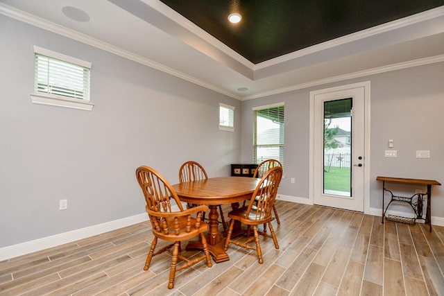 dining space featuring baseboards, ornamental molding, and light wood-style flooring