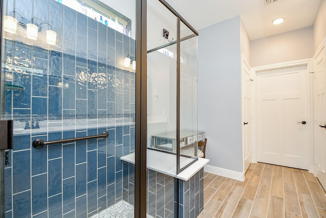 full bathroom with baseboards, a shower stall, and wood finished floors