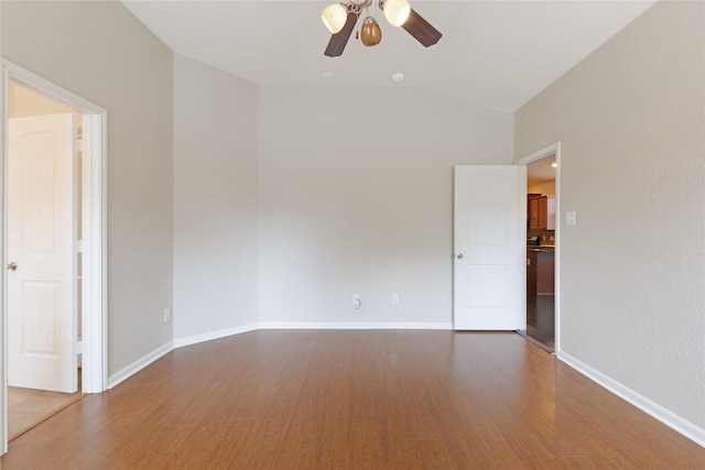 unfurnished room featuring baseboards, lofted ceiling, ceiling fan, and wood finished floors