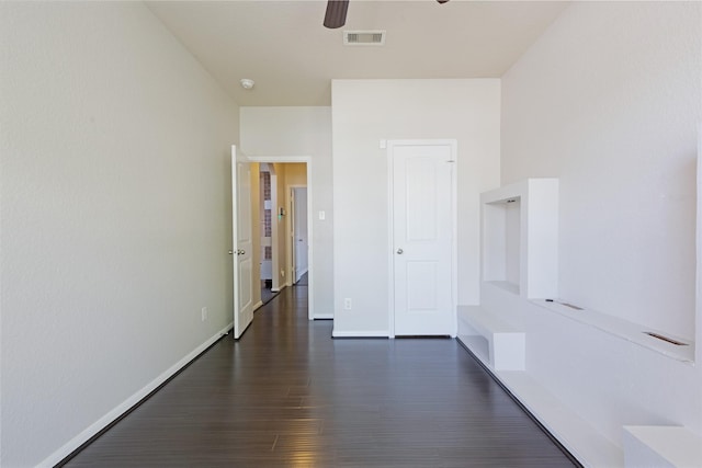 hall with baseboards, dark wood-type flooring, and visible vents