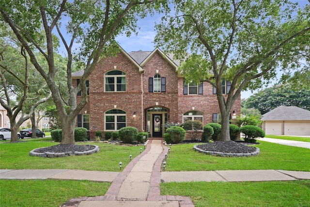 view of front facade featuring a front lawn, brick siding, and a garage