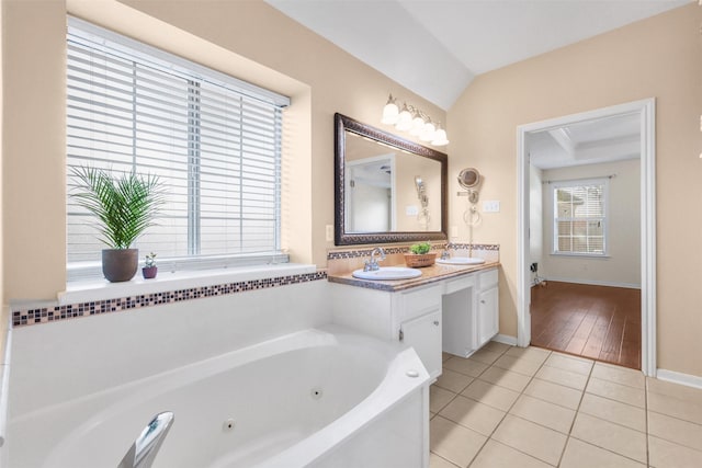 full bathroom featuring tile patterned flooring, baseboards, a sink, and a tub with jets