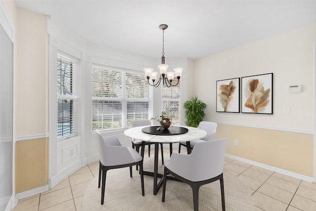 dining area featuring baseboards, a notable chandelier, and light tile patterned floors
