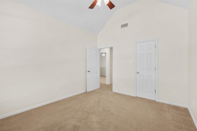 unfurnished bedroom with visible vents, light carpet, baseboards, and high vaulted ceiling