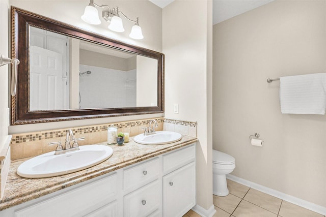 bathroom with double vanity, tile patterned floors, toilet, and a sink