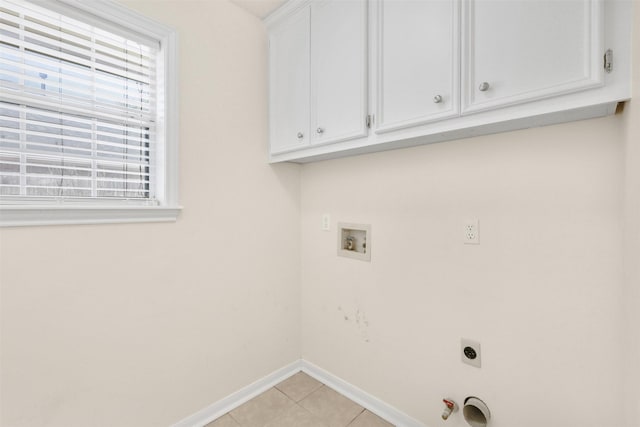 clothes washing area with light tile patterned floors, hookup for an electric dryer, gas dryer hookup, baseboards, and cabinet space