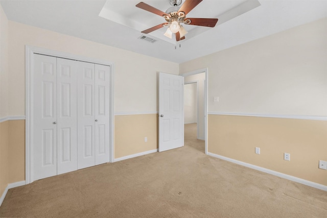 unfurnished bedroom featuring baseboards, visible vents, carpet floors, and a closet