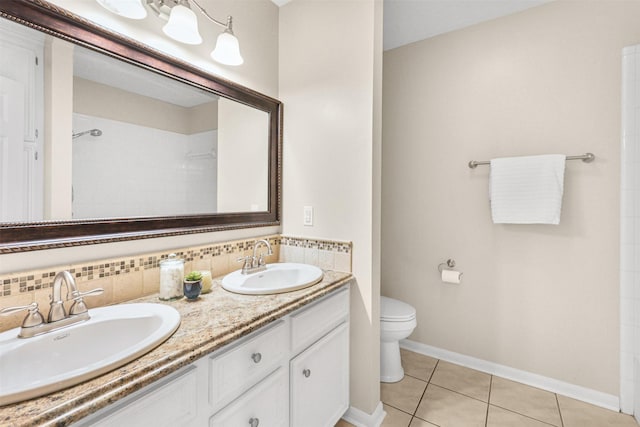 bathroom with double vanity, tile patterned flooring, toilet, and a sink