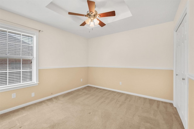 carpeted spare room with baseboards and ceiling fan