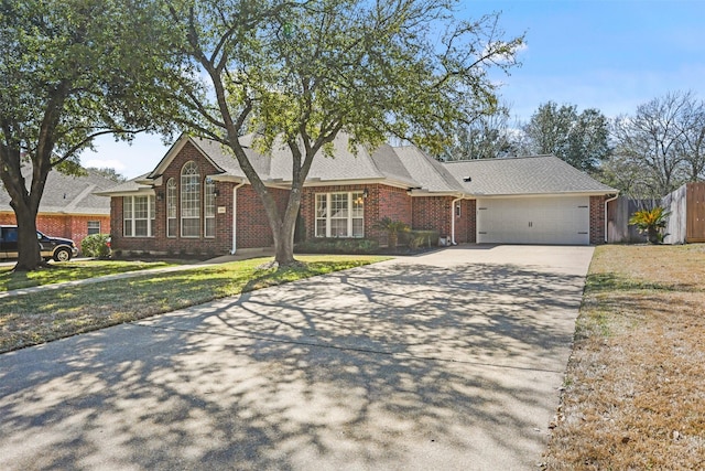 view of front of home featuring an attached garage, driveway, fence, and brick siding
