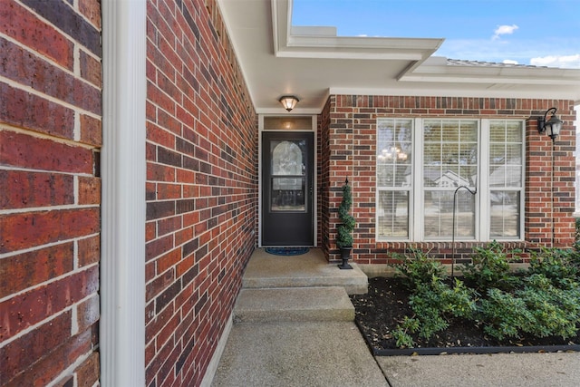 doorway to property with brick siding