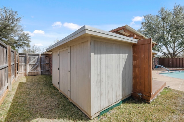 view of shed with a fenced backyard and a fenced in pool