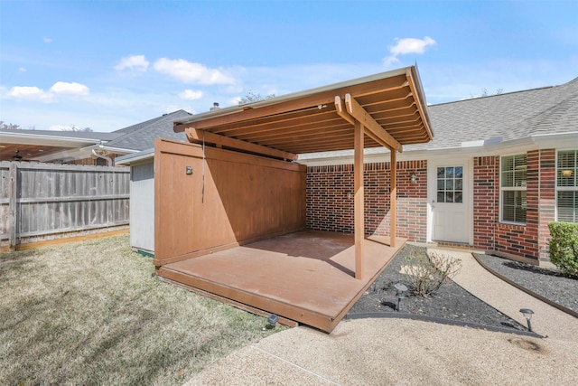 view of patio / terrace with an outdoor structure and fence