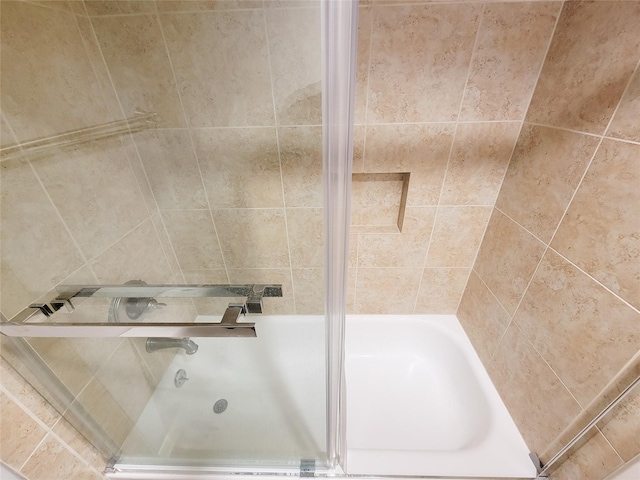 full bath featuring a tub to relax in and a shower with door