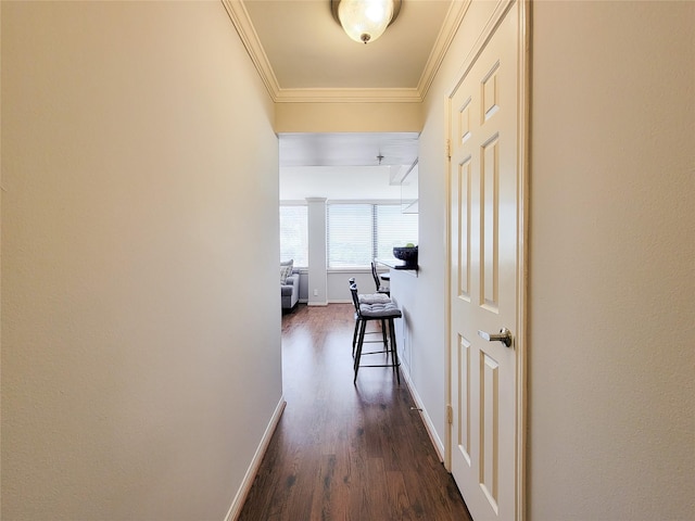 corridor featuring baseboards, dark wood finished floors, and crown molding